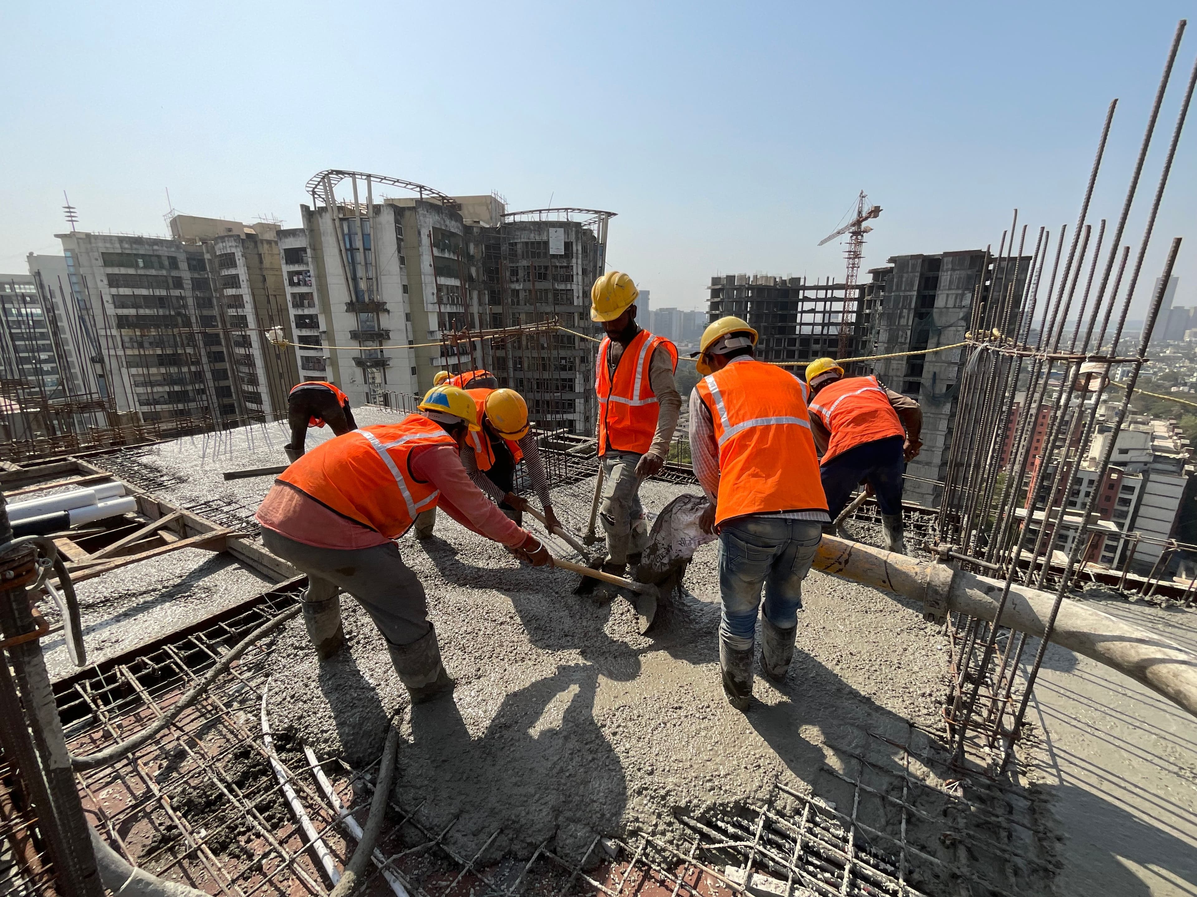 Workers pouring concrete at a construction site.